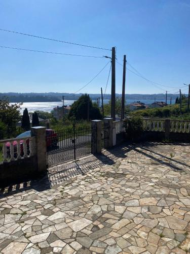 a fence with a stone patio with a view of the water at A casa de Roque 2 in Miño