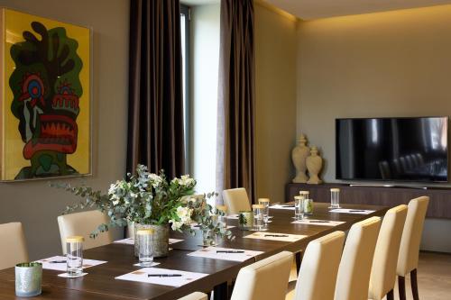 a dining room with a long table with white chairs at Domotel Kastri in Athens