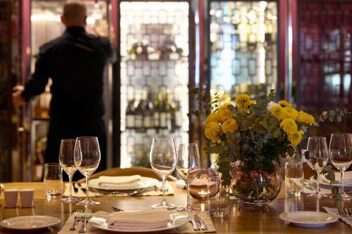 a table with wine glasses and a vase of flowers at Domotel Kastri in Athens