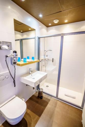a bathroom with a sink and a shower and a toilet at Rivage Hotel Restaurant Lutry in Lausanne