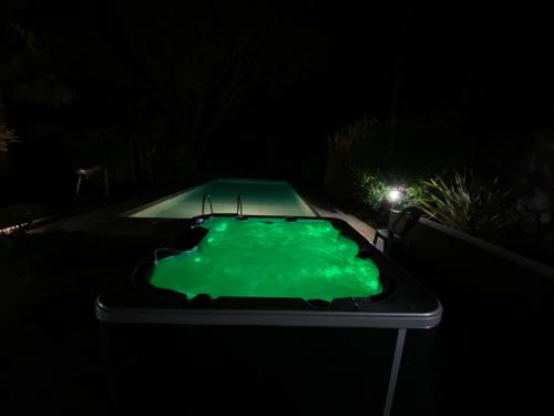 - une piscine dans l'obscurité avec un liquide vert dans l'établissement VILLA & SPA-SAUNA-PISCINE-MASSAGES du 