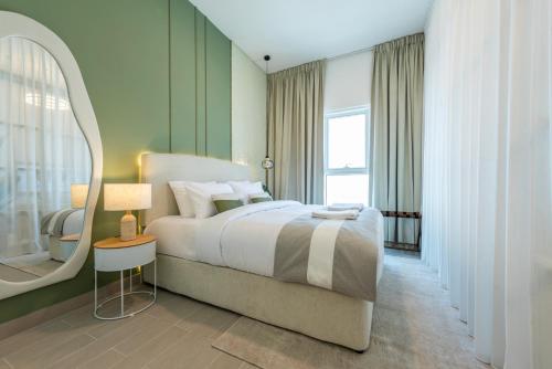 a bedroom with a large bed and a mirror at Dubai Hills - 1BR Luxe Apartment - Golfville - by UDH in Dubai