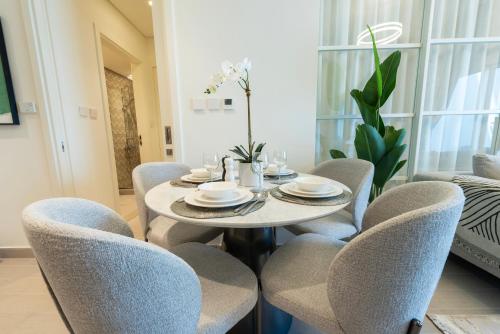 a dining room with a table and chairs at Dubai Hills - 1BR Luxe Apartment - Golfville - by UDH in Dubai