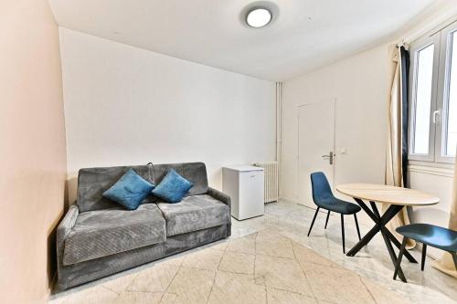 un salon avec un canapé et une table dans l'établissement Studio spacieux Rez-de-chaussée banlieue Paris- II, à Gournay-sur-Marne