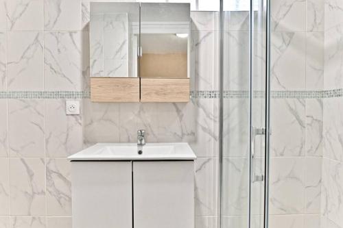 une salle de bain blanche avec un lavabo et une douche dans l'établissement Studio spacieux Rez-de-chaussée banlieue Paris- II, à Gournay-sur-Marne