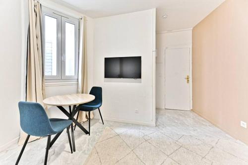 - un salon avec une table, des chaises et une télévision dans l'établissement Studio spacieux Rez-de-chaussée banlieue Paris- II, à Gournay-sur-Marne