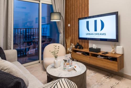 a living room with a tv and a couch at Dubai Hills - 1BR Luxe Apartment - Golfville - by UDH in Dubai