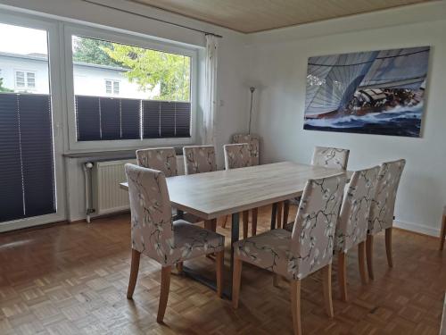 a dining room with a wooden table and chairs at Strandhaus Deichvoigt in Cuxhaven