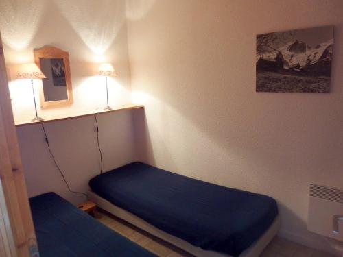 - une petite chambre avec un lit bleu dans l'établissement 2 pièces, 6 pers, piscine, animaux admis, parking - FR-1-263-141, à Valloire