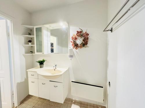 un bagno bianco con lavandino e specchio di aday - Beautiful 3 bedrooms apartment on Jomfru AneGade ad Aalborg