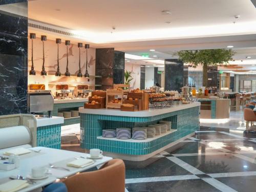 un restaurante con un mostrador con platos en Rotana Al Manakha Madinah, en Medina