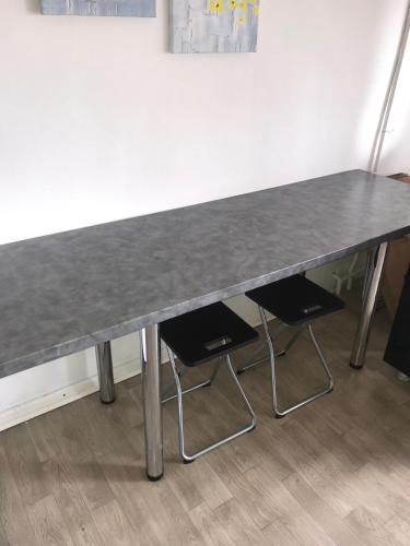 a large gray table with two chairs in a room at CENTRAL ROOMS WITH GREAT VIEW shared bathroom no parking in Skopje