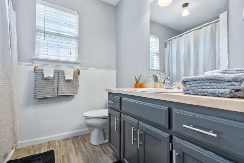 Un baño con lavabo, inodoro y espejo. en Holly House Cleveland, en Cleveland