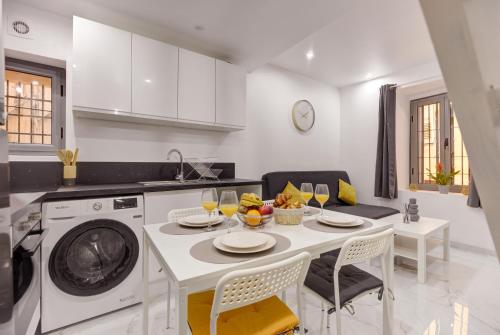 une cuisine avec une table et une machine à laver dans l'établissement Escapade Grassoise, à Grasse