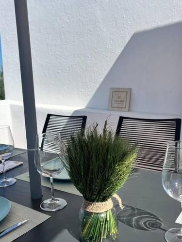 a table with wine glasses and a vase with grass at Casa Alentejana - Casa Olival in Nisa