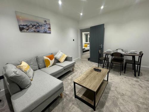 a living room with a couch and a table at Modern 3bed, Garden, Surbiton St in Surbiton
