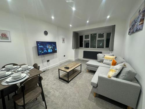 a living room with a couch and a table at Modern 3bed, Garden, Surbiton St in Surbiton