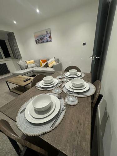 a dining room table with plates and wine glasses on it at Modern 3bed, Garden, Surbiton St in Surbiton