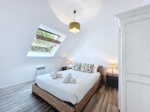 une chambre avec un lit et une lucarne dans l'établissement Ker Lodan jolie maison 3 chambres et terrasse, à Brest