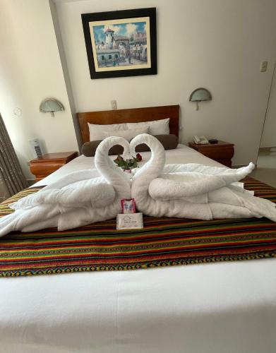 two swansrendered to look like hearts sitting on a bed at Flower's House MachuPicchu in Machu Picchu