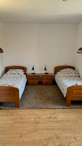 two beds in a room with two tables and two lamps at Dom Pracy Twórczej Stowarzyszenia Filmowców Polskich w Kazimierzu Dolnym in Kazimierz Dolny