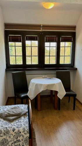 a room with a table and two chairs and windows at Dom Pracy Twórczej Stowarzyszenia Filmowców Polskich w Kazimierzu Dolnym in Kazimierz Dolny