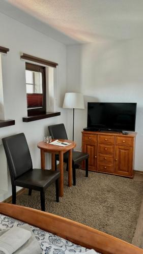 a living room with a table and two chairs and a television at Dom Pracy Twórczej Stowarzyszenia Filmowców Polskich w Kazimierzu Dolnym in Kazimierz Dolny