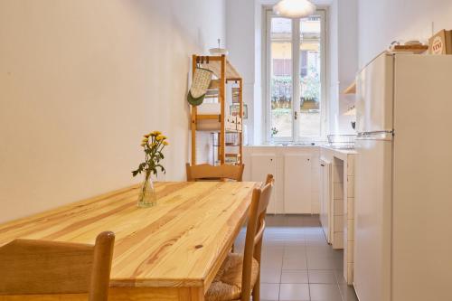 una cucina con un tavolo di legno e un frigorifero di Classic Commenda - Porta Romana a Milano