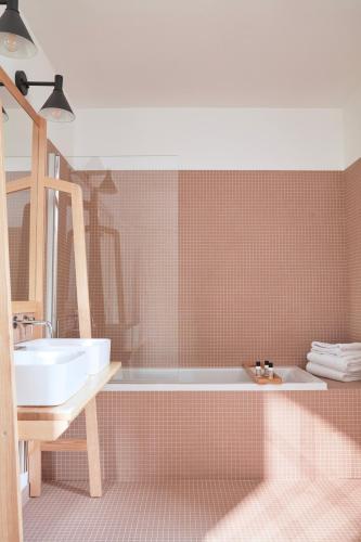 une salle de bain avec une baignoire et un lavabo dans l'établissement La Bastide du Mourre, à Oppède