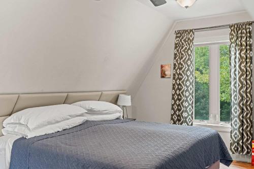 a white bedroom with a bed and a window at Old Rag A-Frame: Mountain Views Hot Tub Fire Pit in Etlan