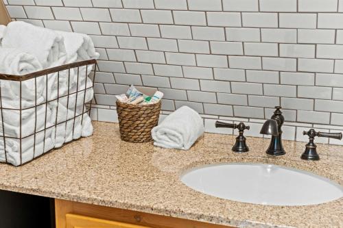 a bathroom counter with a sink and a basket of towels at Old Rag A-Frame: Mountain Views Hot Tub Fire Pit in Etlan