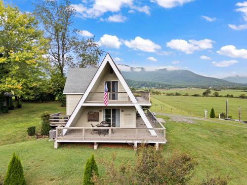 a house with a porch with a flag on it at Old Rag A-Frame: Mountain Views Hot Tub Fire Pit in Etlan