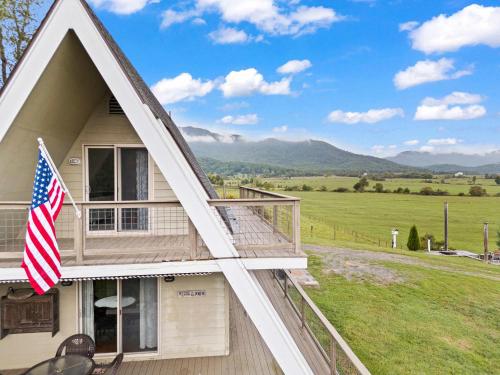 a house with an american flag on the porch at Old Rag A-Frame: Mountain Views Hot Tub Fire Pit in Etlan