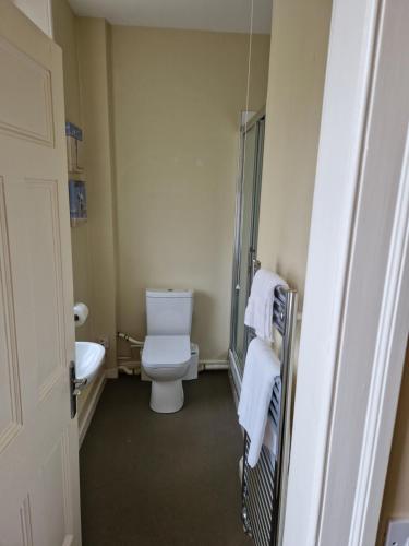 a bathroom with a toilet and a sink with towels at Neidpath Inn in Peebles