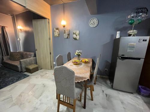 a dining room with a table and a refrigerator at Bayu Beach Resort Port Dickson Santai PD Homestay 2 Bedroom Apartment in Port Dickson