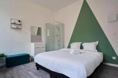 a bedroom with a large white bed with a green headboard at Maison 4 chambres et jacuzzi pour 8 personnes in Roubaix