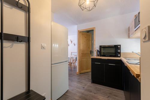 a kitchen with a refrigerator and a microwave at Séjour à 6 - 200m des pistes - Belle Sayette in Val Louron