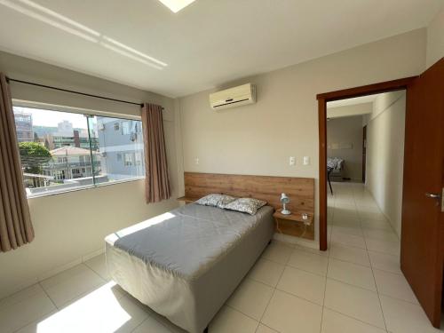 a bedroom with a bed and a large window at Residencial Alianza - Depto de 1 habitacion 203 in Bombas