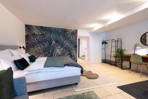 a bedroom with a large bed and a desk at Traumwerk24 - Altstadt Suite Augsburg in Augsburg