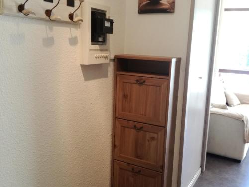 Cette chambre comprend une armoire en bois et un lit. dans l'établissement Studio cabine cosy au pied des pistes avec balcon - FR-1-557-115, à Les Adrets