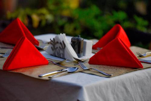 a table with red napkins and forks and spoons at Mara Chui Eco-Resort in Sekenani