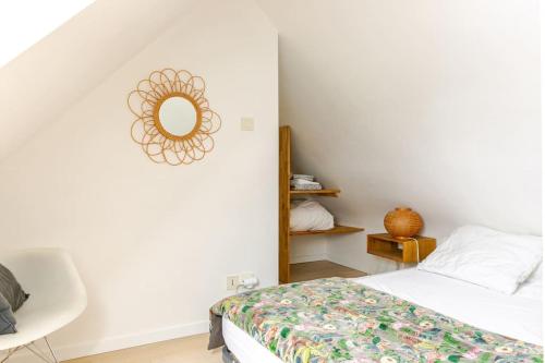 a bedroom with a bed and a mirror on the wall at A 600 m de la plage avec jardinet privatif in Saint-Pierre-Quiberon