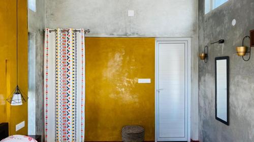 a room with a white door and a yellow wall at HappyHideaway in Vagamon