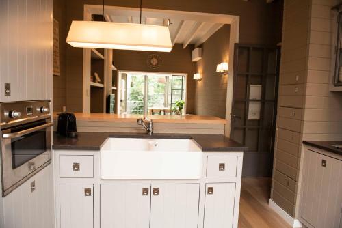 una cucina con lavandino bianco e finestra di Family house with sauna close to the sea a Ostenda