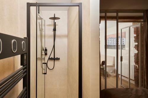 La salle de bains est pourvue d'une porte en verre et d'une douche. dans l'établissement Stylish 2BR & 2BA with private terrace, à Paris