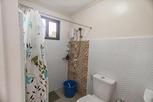 a bathroom with a toilet and a shower at Intoy's Place Panglao near Beach in Panglao