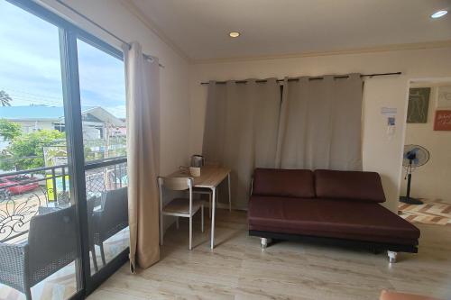 a living room with a couch and a table and a balcony at Intoy's Place Panglao near Beach in Panglao