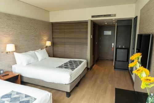 a hotel room with a bed and a television at Hotel Terrado Cavancha in Iquique