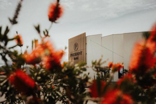 a building with red flowers in front of it at Hotel President in Čapljina