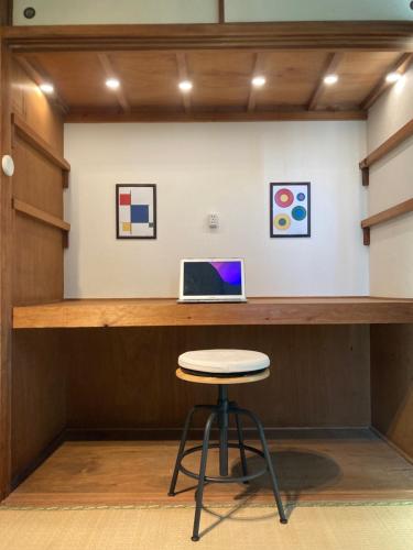 a bar with a stool and a laptop on a counter at Oita City バケーション コンドミニアム in Oita